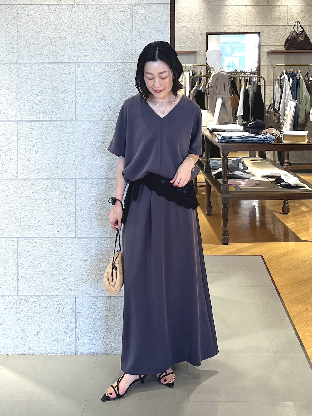 グレー系のスカート、ブラック系のサンダル、グレー系のTシャツ/カットソーを着用したレディースの春コーディネートの2枚目の写真