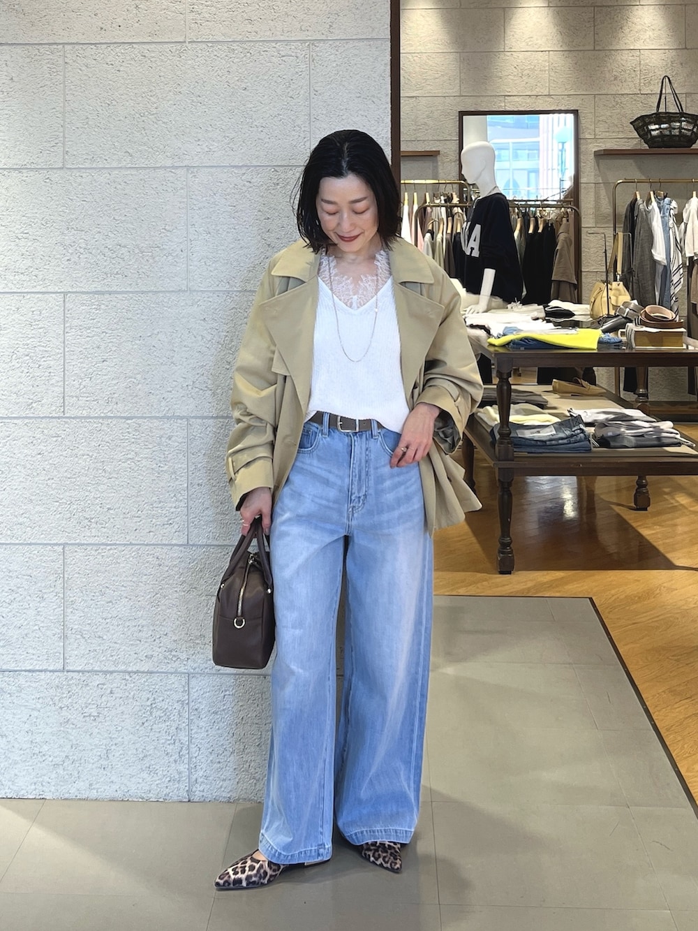 ベージュ系のその他シューズ、ブラウン系のボストンバッグ、ブルー系のデニムパンツを着用したレディースの春コーディネートの2枚目の写真