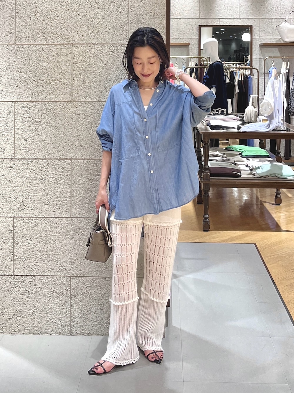 グレー系のトートバッグ、ホワイト系のその他パンツ、ブルー系のシャツ/ブラウスを着用したレディースの夏コーディネートの2枚目の写真