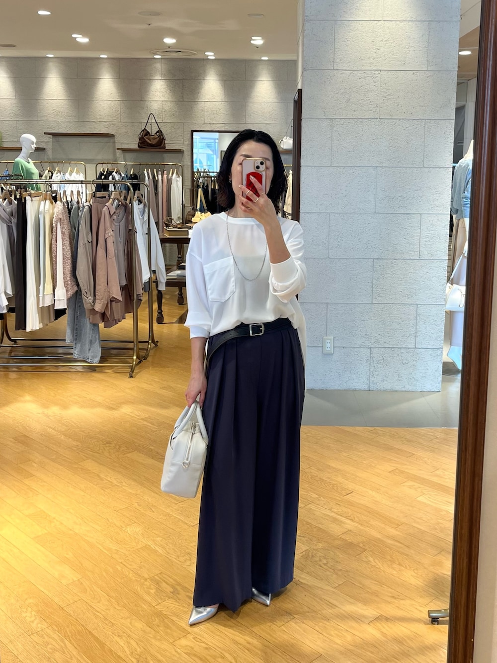 グレー系のスラックス、シルバー系のその他シューズ、ホワイト系のボストンバッグを着用したレディースの春コーディネートの4枚目の写真