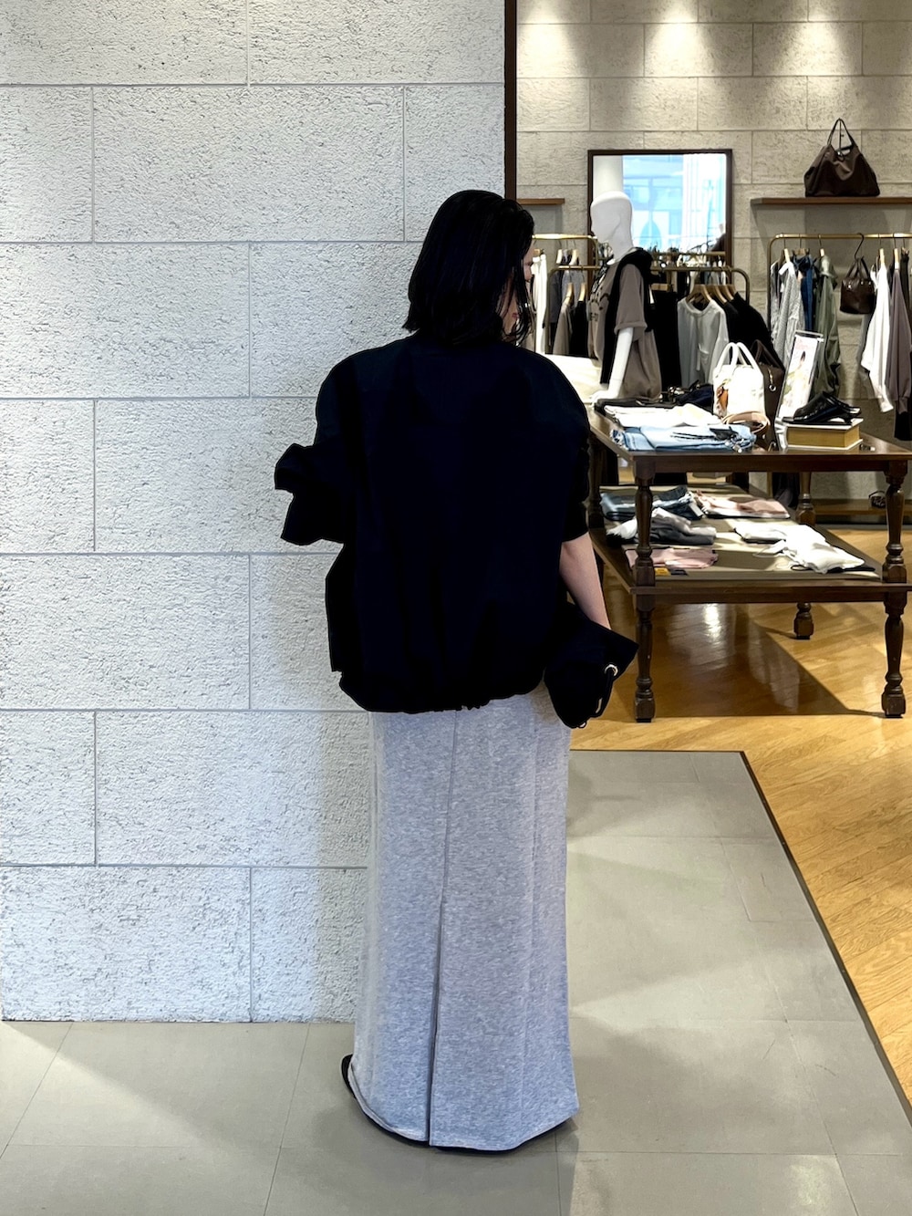 ブラック系のその他シューズ、グレー系のスカート、ブラック系のトートバッグを着用したレディースの春コーディネートの4枚目の写真