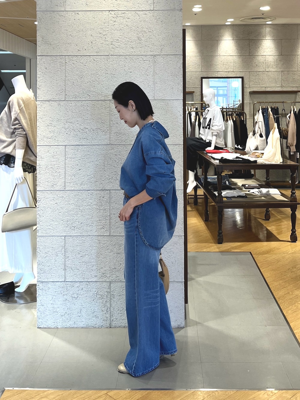 ベージュ系のショルダーバッグ、ブルー系のシャツ/ブラウス、グレー系のTシャツ/カットソーを着用したレディースの冬コーディネートの3枚目の写真