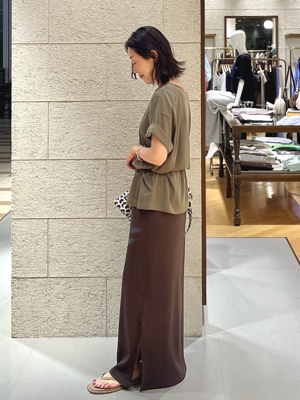 ブラウン系のワンピース、グリーン系のTシャツ/カットソー、ベージュ系のサンダルを着用したレディースの夏コーディネートの2枚目の写真