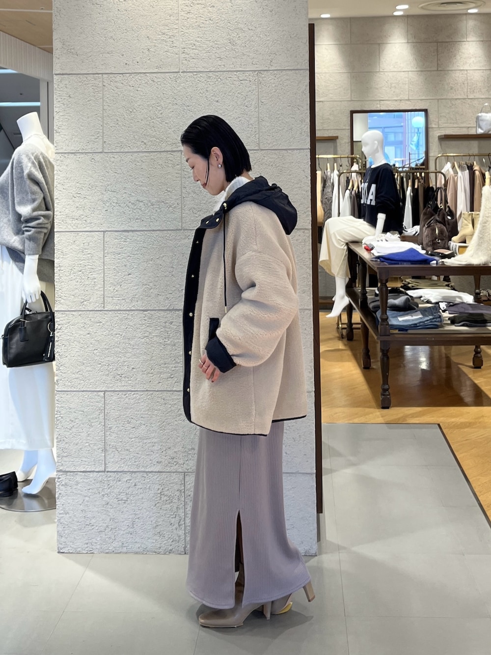 ベージュ系のワンピース、ホワイト系のニット/セーター、ベージュ系のその他アウターを着用したレディースの冬コーディネートの3枚目の写真