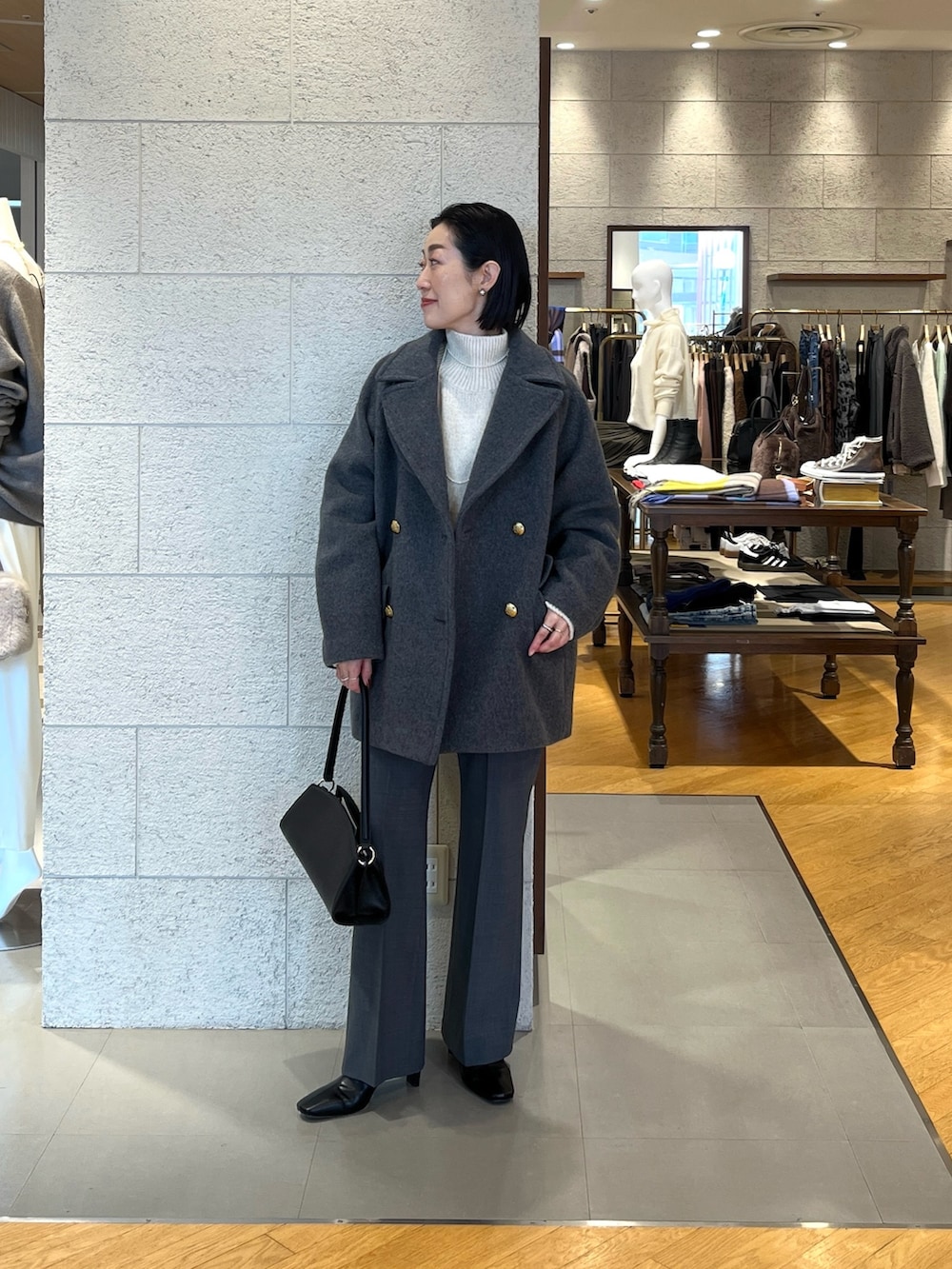 ホワイト系のニット/セーター、ブラック系のハンドバッグ、グレー系のその他パンツを着用したレディースの秋コーディネートの5枚目の写真