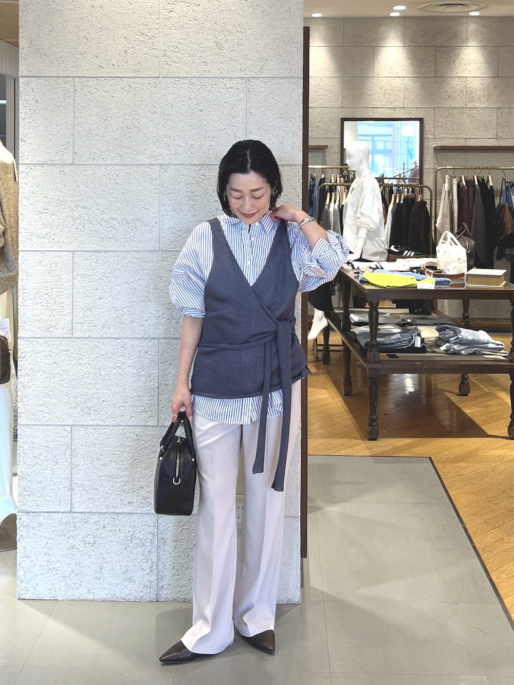 ベージュ系のその他パンツ、ブラウン系のその他シューズ、ブラック系のボストンバッグを着用したレディースの冬コーディネートの2枚目の写真