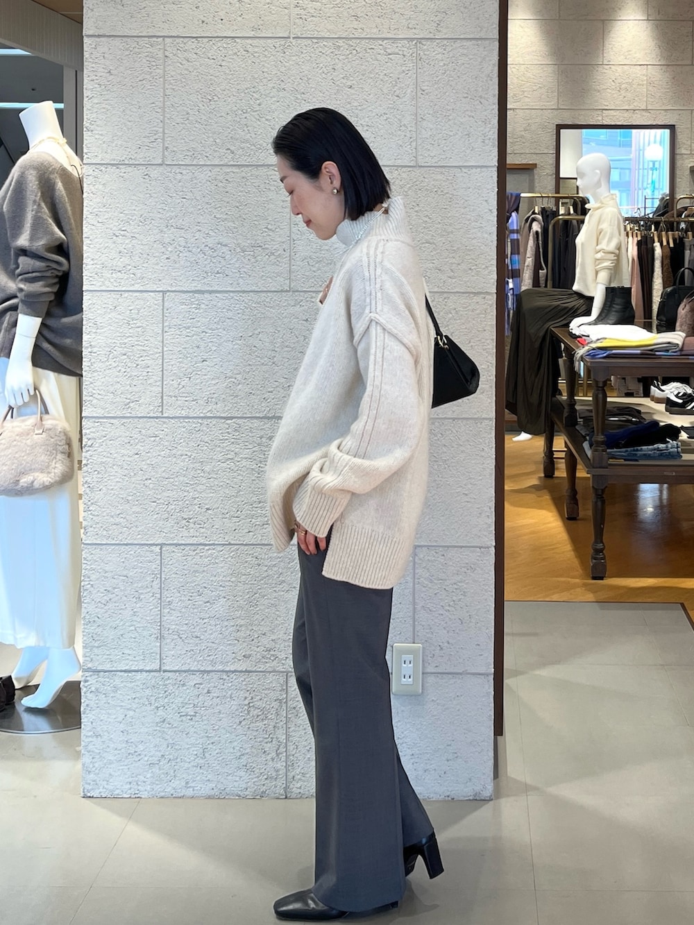 ホワイト系のニット/セーター、ブラック系のハンドバッグ、グレー系のその他パンツを着用したレディースの秋コーディネートの3枚目の写真