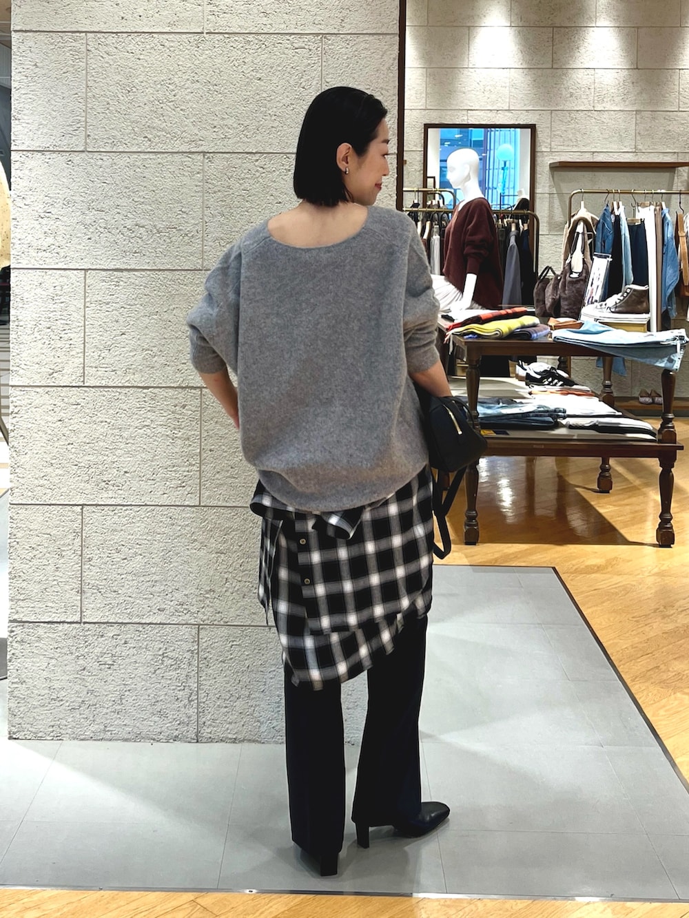 ブラウン系のブーツ、グレー系のニット/セーター、ブラック系のその他パンツを着用したレディースの秋コーディネートの3枚目の写真