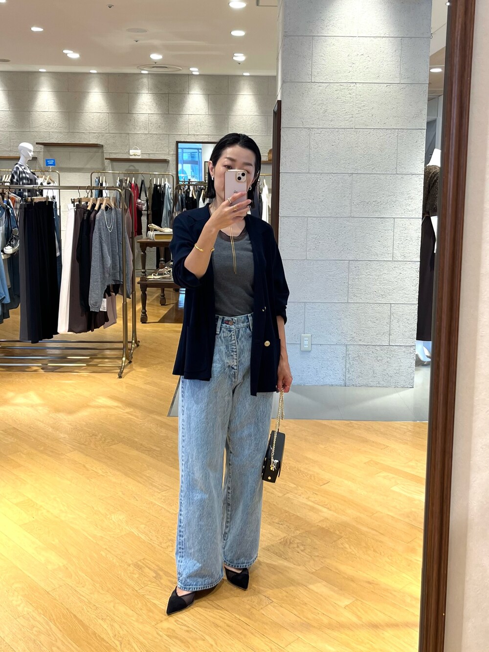 ブラック系のパンプス、ブルー系のテーラードジャケット、ブルー系のデニムパンツを着用したレディースの夏コーディネートの5枚目の写真