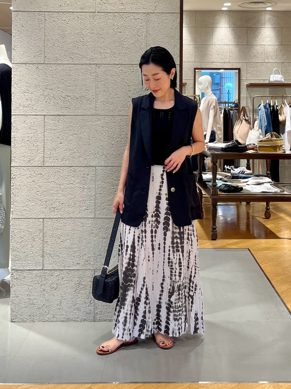 ブラック系のニット/セーター、ブラック系のスカート、ブラック系のベストを着用したレディースの夏コーディネートの2枚目の写真