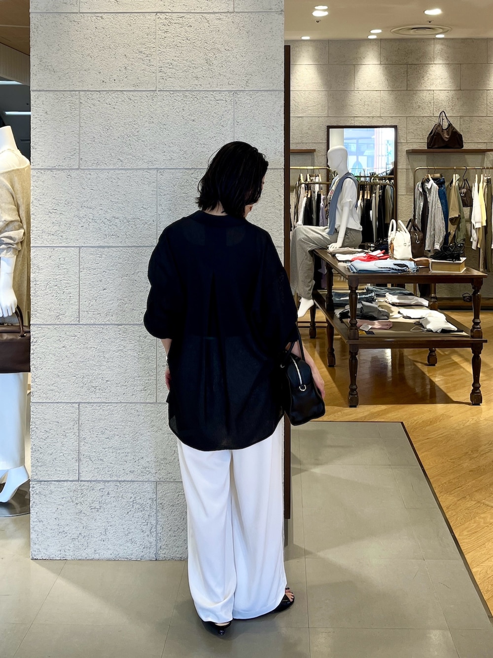 ブラック系のボストンバッグ、ブラック系のシャツ/ブラウス、グレー系のタンクトップを着用したレディースの春コーディネートの4枚目の写真