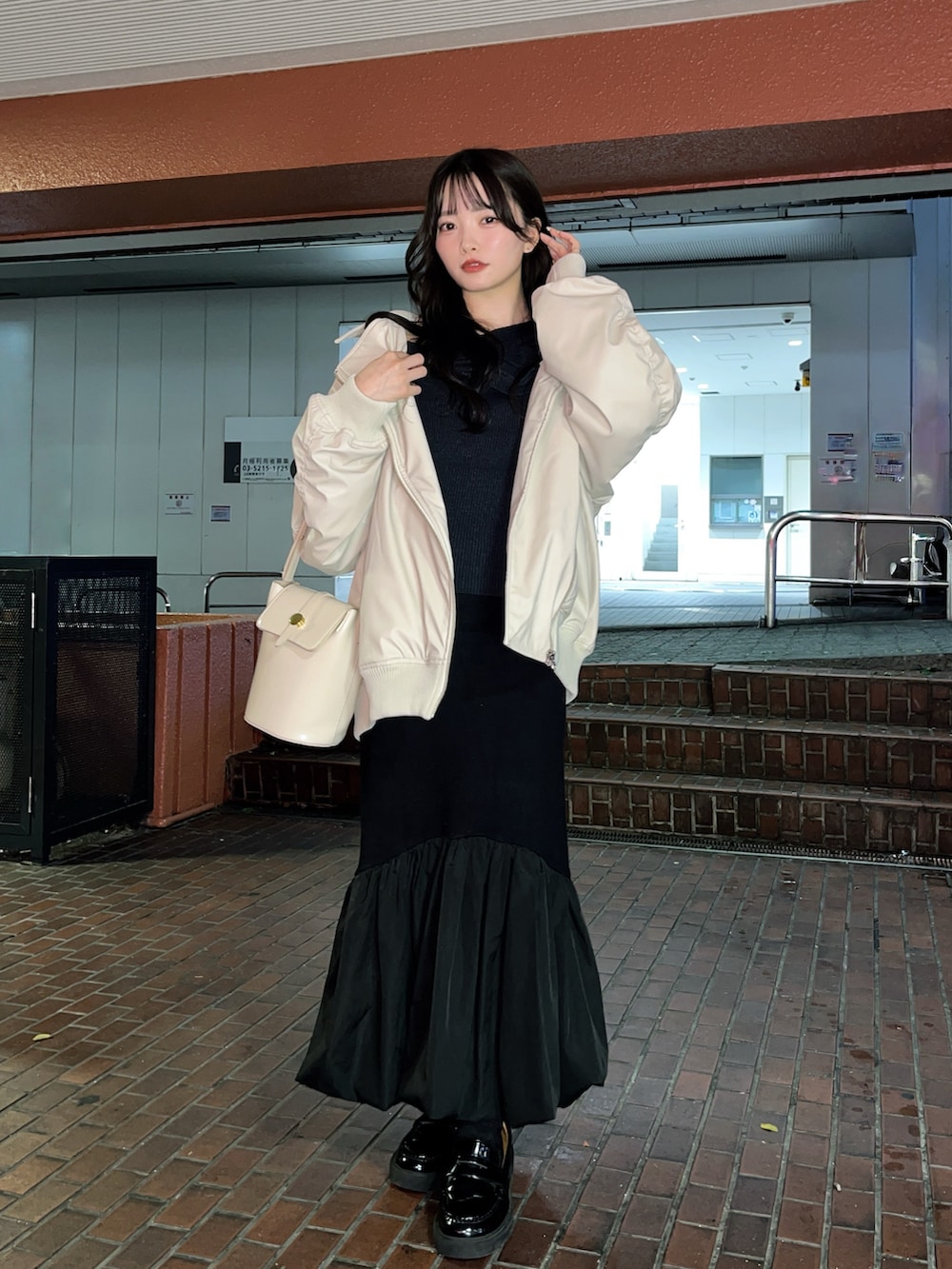 ベージュ系のライダースジャケット、ブラック系のスカート、ブラック系のローファーを着用したレディースの秋コーディネートの5枚目の写真