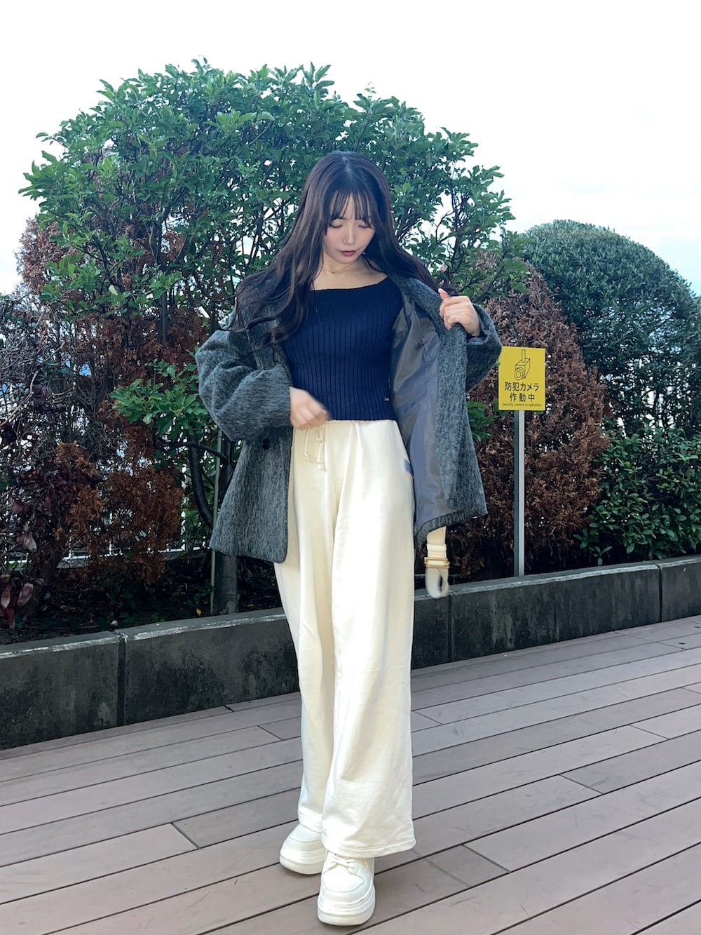 グレー系のテーラードジャケット、ブルー系のニット/セーター、ホワイト系のスニーカーを着用したレディースの秋コーディネートの3枚目の写真