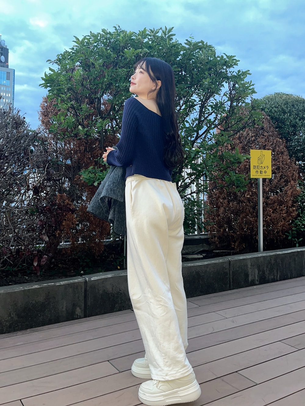 グレー系のテーラードジャケット、ブルー系のニット/セーター、ホワイト系のスニーカーを着用したレディースの秋コーディネートの5枚目の写真