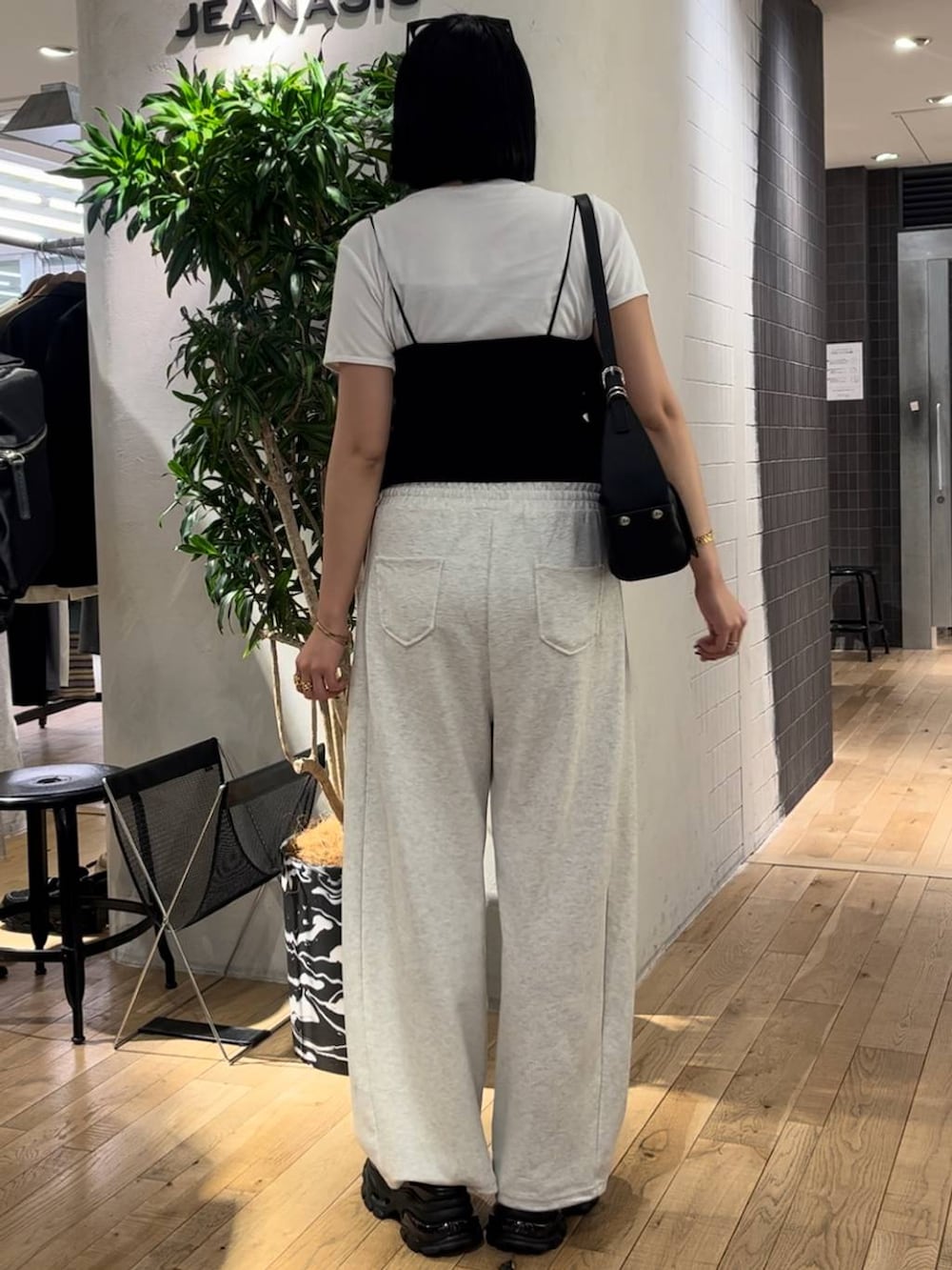 ブラック系のサンダル、ホワイト系のTシャツ/カットソー、ブラック系のショルダーバッグを着用したレディースの夏コーディネートの3枚目の写真