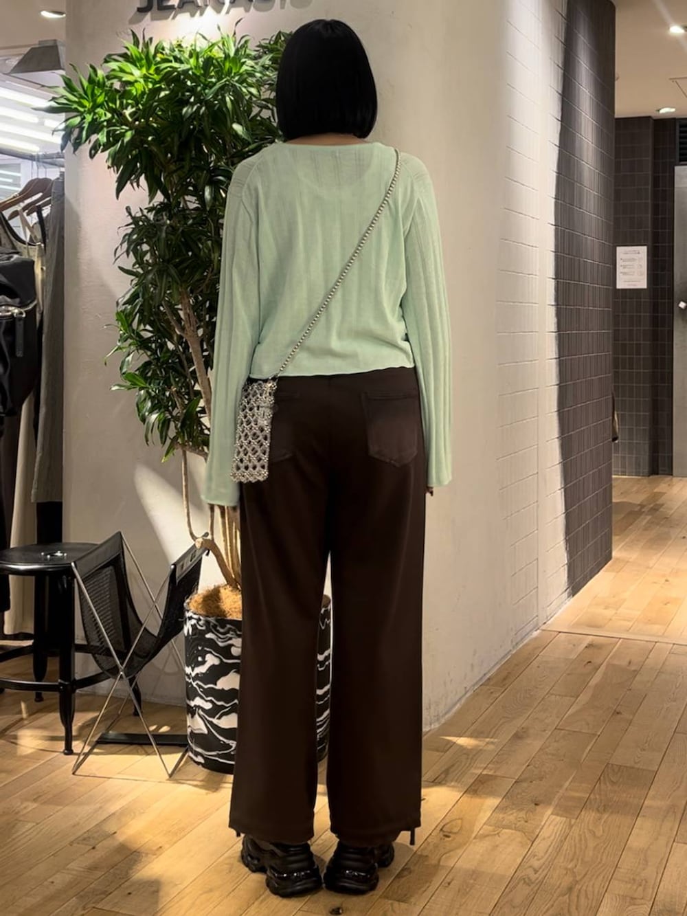 グリーン系のカーディガン/ボレロ、ブラウン系のデニムパンツ、ブラック系のサンダルを着用したレディースの夏コーディネートの3枚目の写真