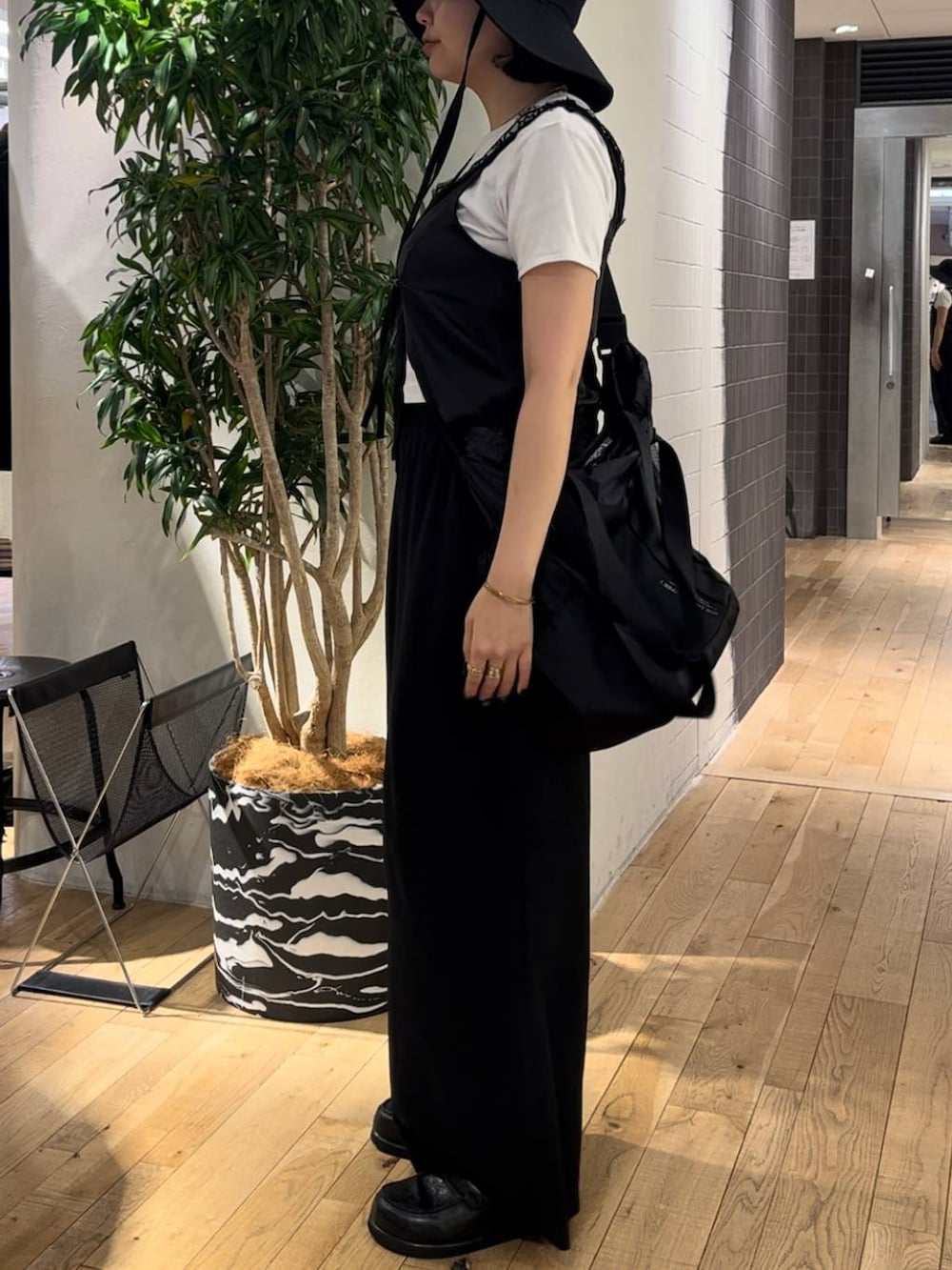 ブラック系のその他パンツ、ブラック系のローファー、ホワイト系のTシャツ/カットソーを着用したレディースの夏コーディネートの2枚目の写真