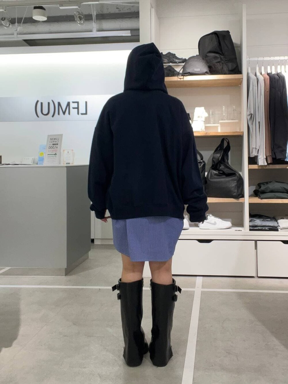 ブルー系のシャツ/ブラウス、ブルー系のパーカー、ブラック系のキャップを着用したレディースの春コーディネートの2枚目の写真