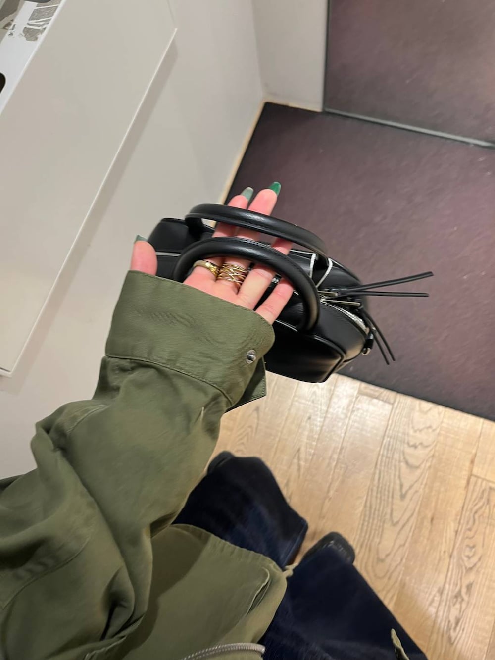 ブラック系のローファー、グリーン系のミリタリージャケット、グレー系のパーカーを着用したレディースの秋コーディネートの5枚目の写真