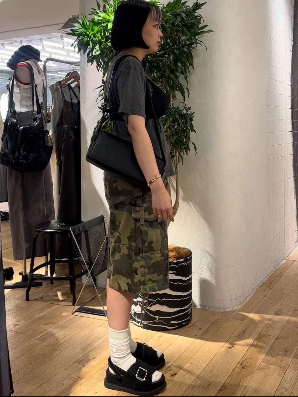 グレー系のTシャツ/カットソー、ブラック系のサンダル、ブラック系のショルダーバッグを着用したレディースの夏コーディネートの4枚目の写真