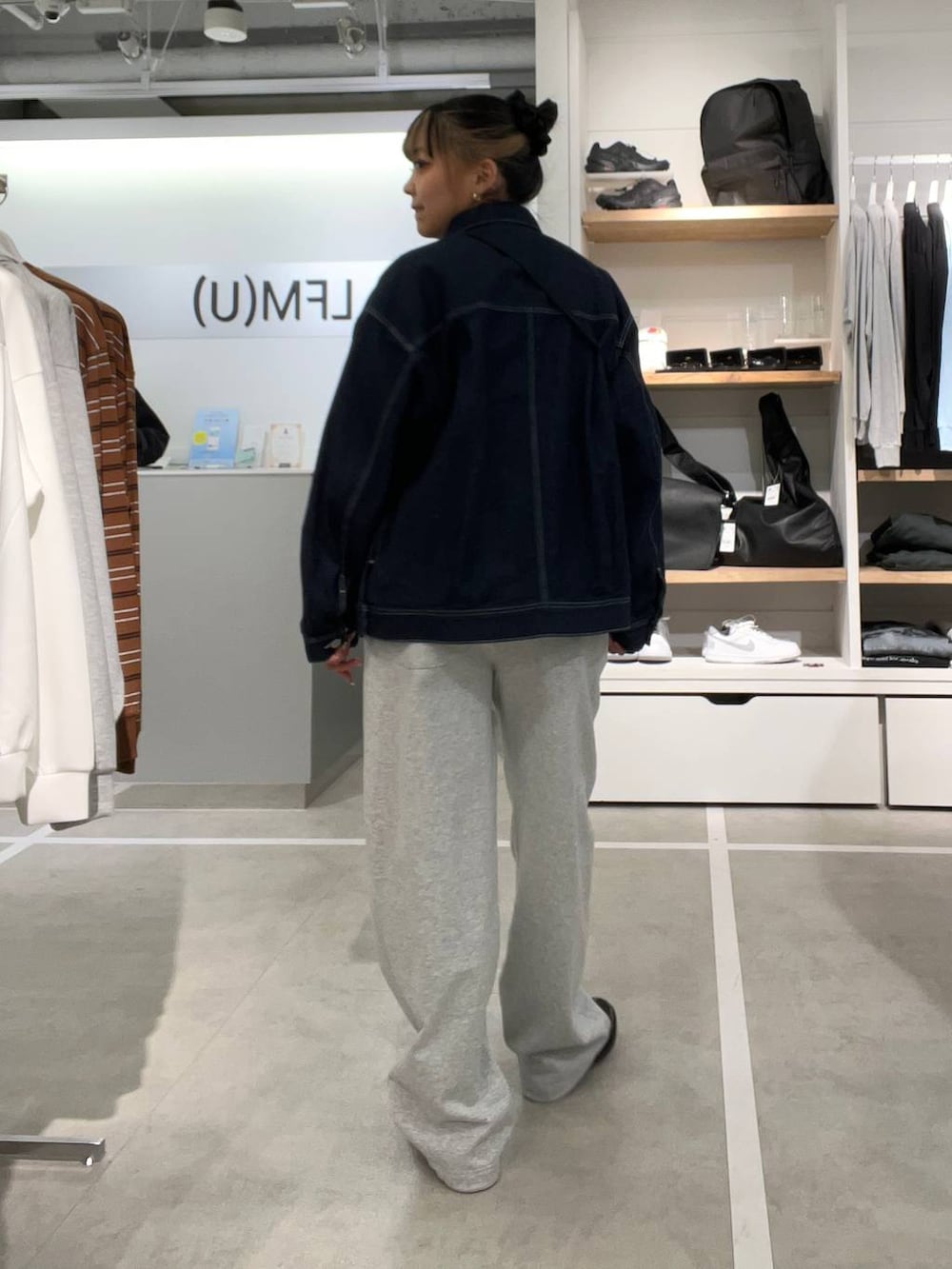 ブラック系のドレスシューズ、ブルー系のデニムジャケット、グレー系のスウェットパンツを着用したレディースの春コーディネートの2枚目の写真