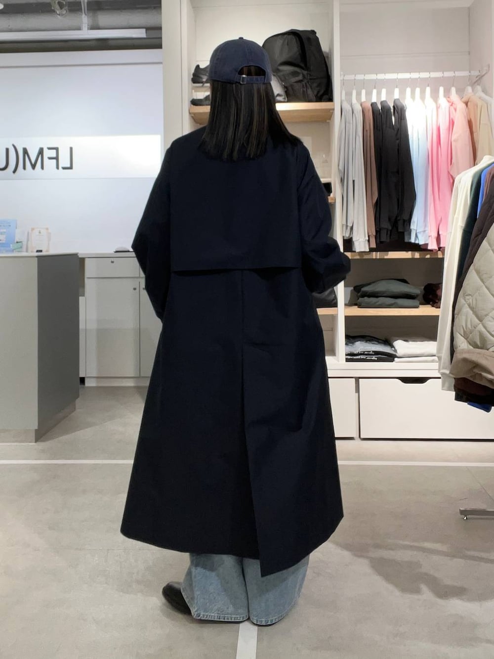 ブラック系のドレスシューズ、ブルー系のデニムパンツ、ブルー系のステンカラーコートを着用したレディースの春コーディネートの2枚目の写真