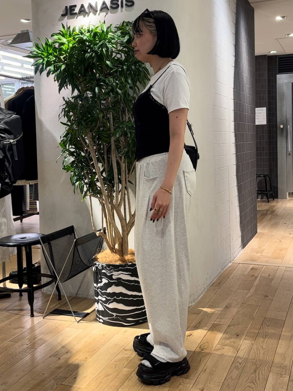 ブラック系のサンダル、ホワイト系のTシャツ/カットソー、ブラック系のショルダーバッグを着用したレディースの夏コーディネートの2枚目の写真