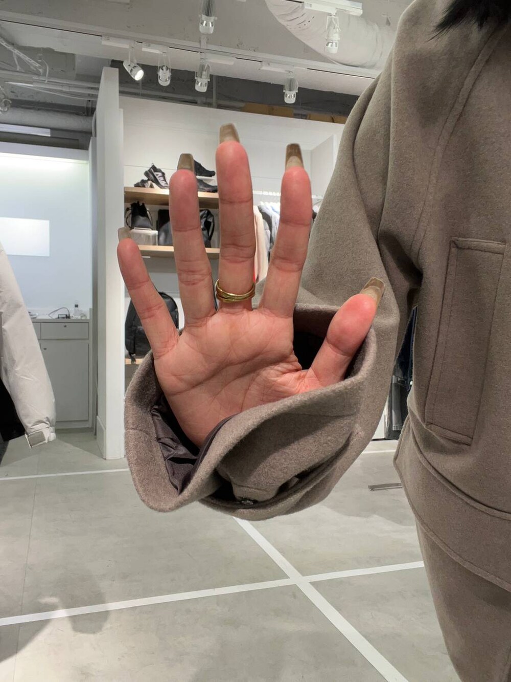 グレー系のスカート、ブラウン系のブルゾンを着用したレディースの秋コーディネートの4枚目の写真