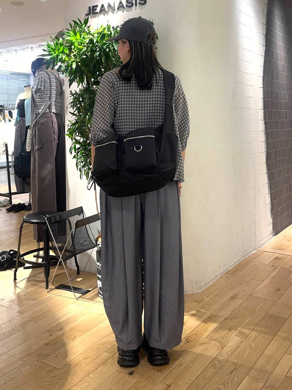 ブラック系のショルダーバッグ、ブラック系のローファー、グレー系のタンクトップを着用したレディースの春コーディネートの3枚目の写真