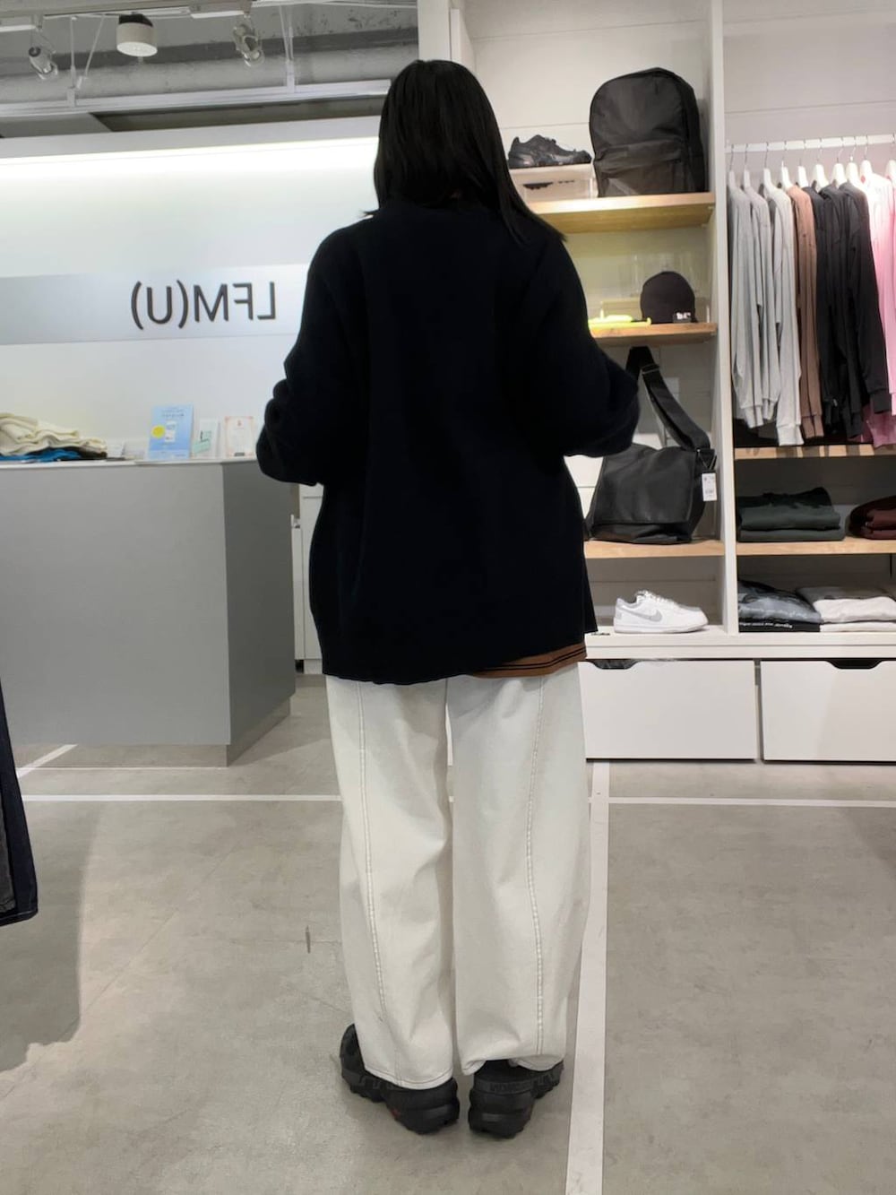 ブラウン系のTシャツ/カットソー、ホワイト系のデニムパンツ、ブルー系のカーディガン/ボレロを着用したレディースの冬コーディネートの2枚目の写真