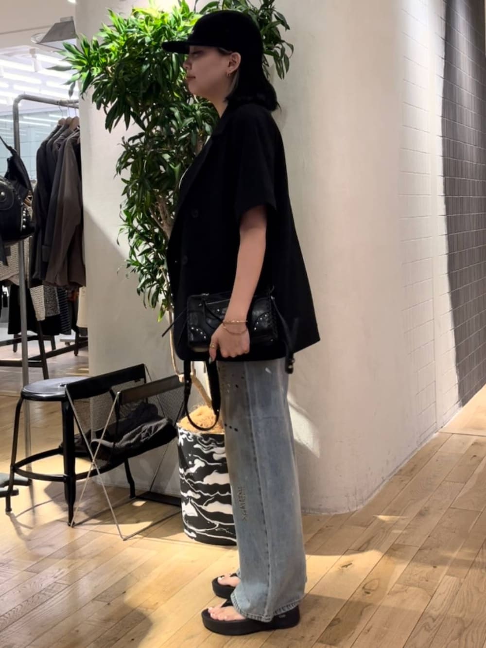 ブルー系のデニムパンツ、ホワイト系のタンクトップ、ブラック系のショルダーバッグを着用したレディースの夏コーディネートの2枚目の写真