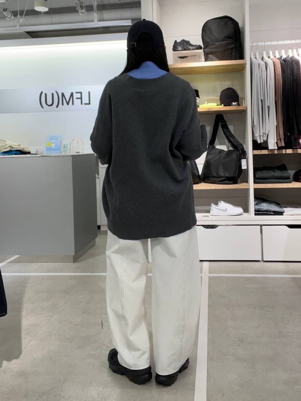 ホワイト系のデニムパンツ、ブルー系のシャツ/ブラウス、グレー系のカーディガン/ボレロを着用したレディースの春コーディネートの2枚目の写真