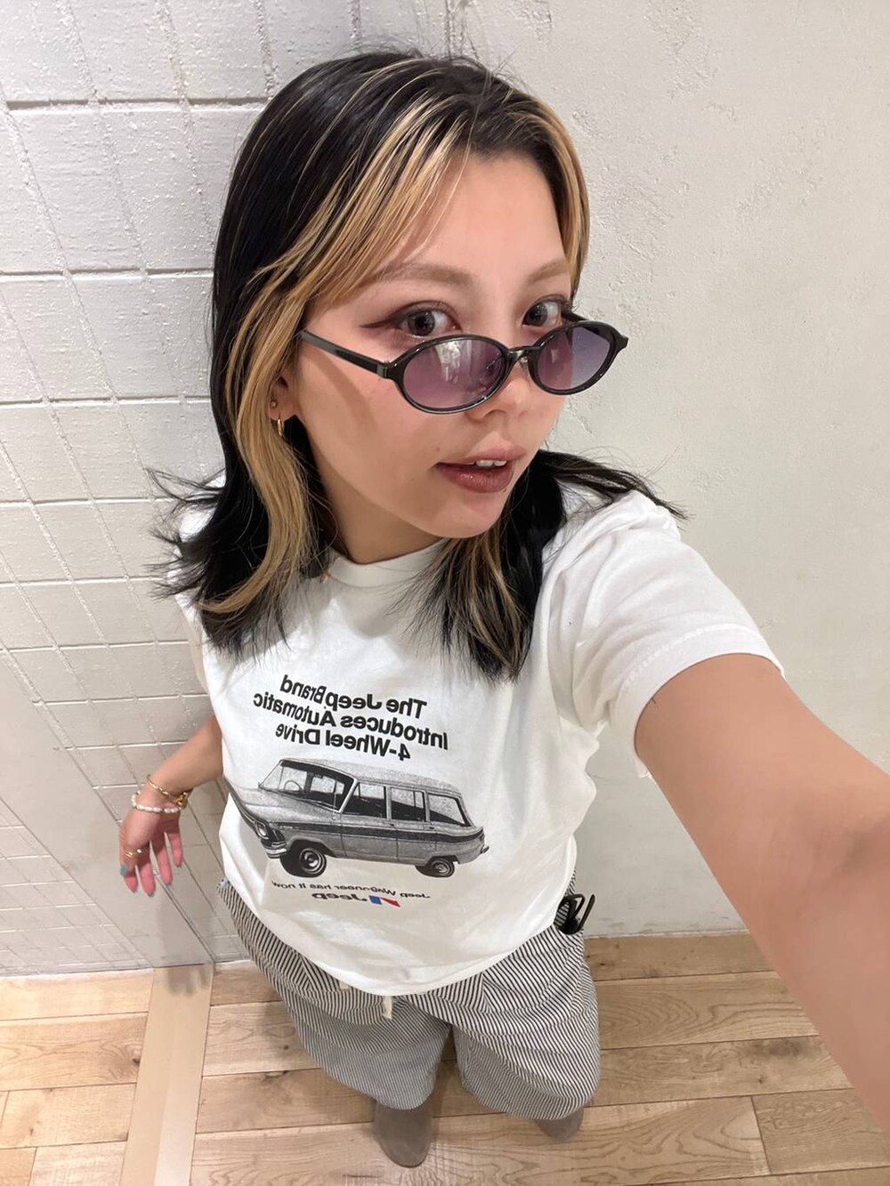 ホワイト系のTシャツ/カットソー、ホワイト系のデニムパンツ、ブラック系のサングラスを着用したレディースの夏コーディネートの2枚目の写真