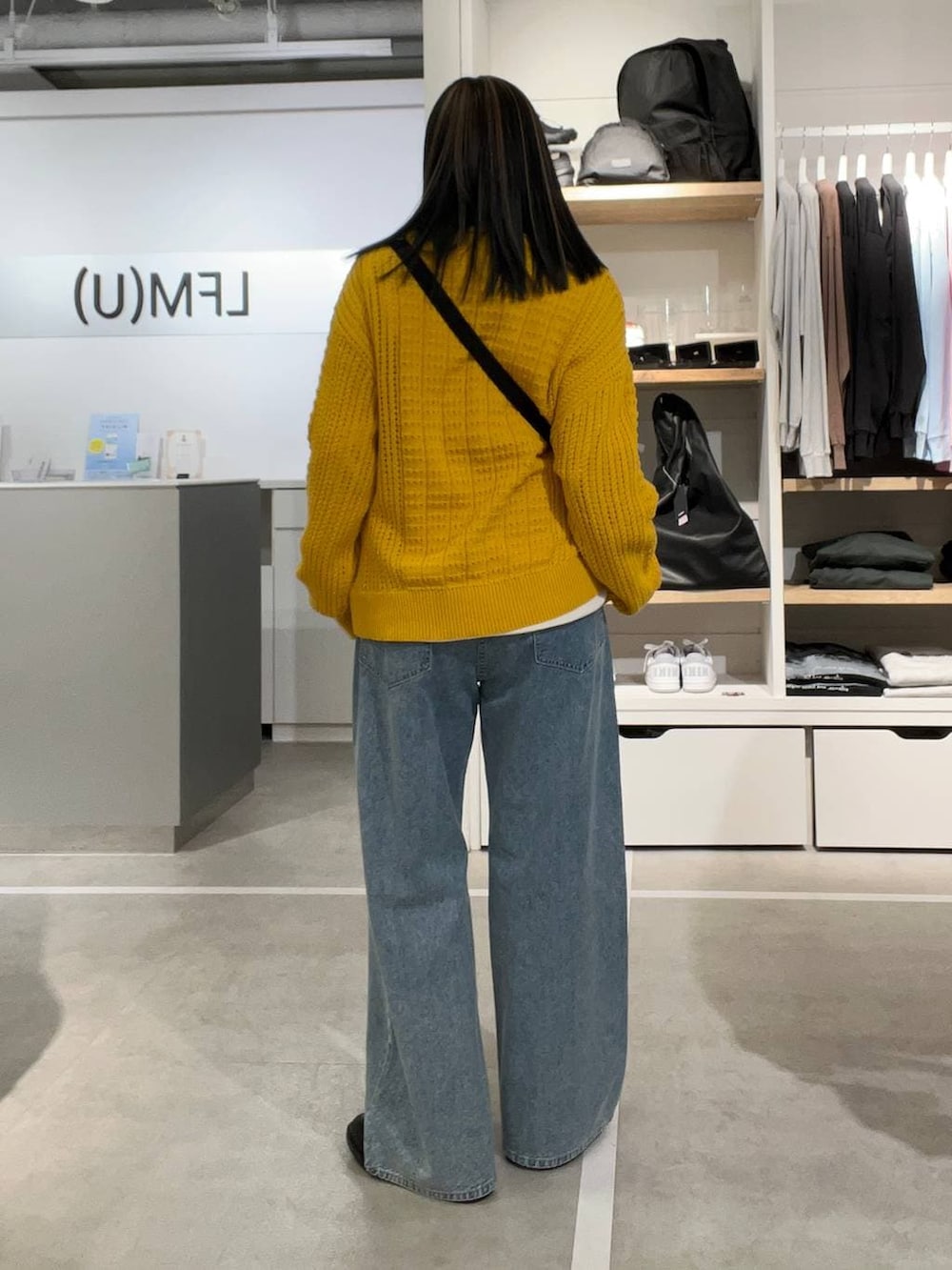 ブラック系のドレスシューズ、ブルー系のデニムパンツ、ブラック系のショルダーバッグを着用したレディースの春コーディネートの2枚目の写真