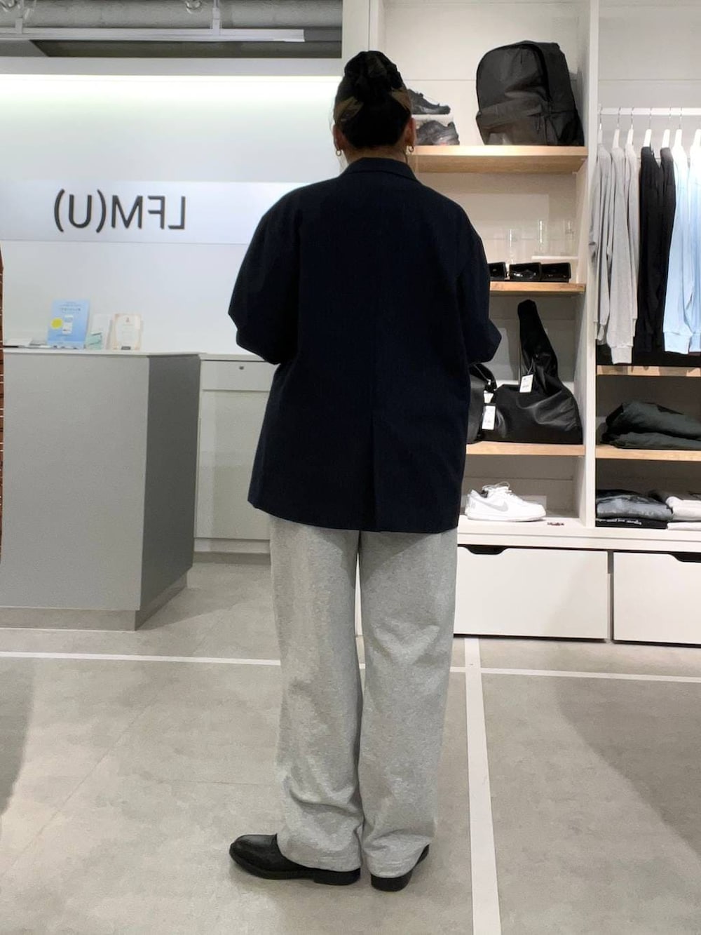 ブラック系のドレスシューズ、グレー系のスウェットパンツ、ブルー系のテーラードジャケットを着用したレディースの春コーディネートの2枚目の写真