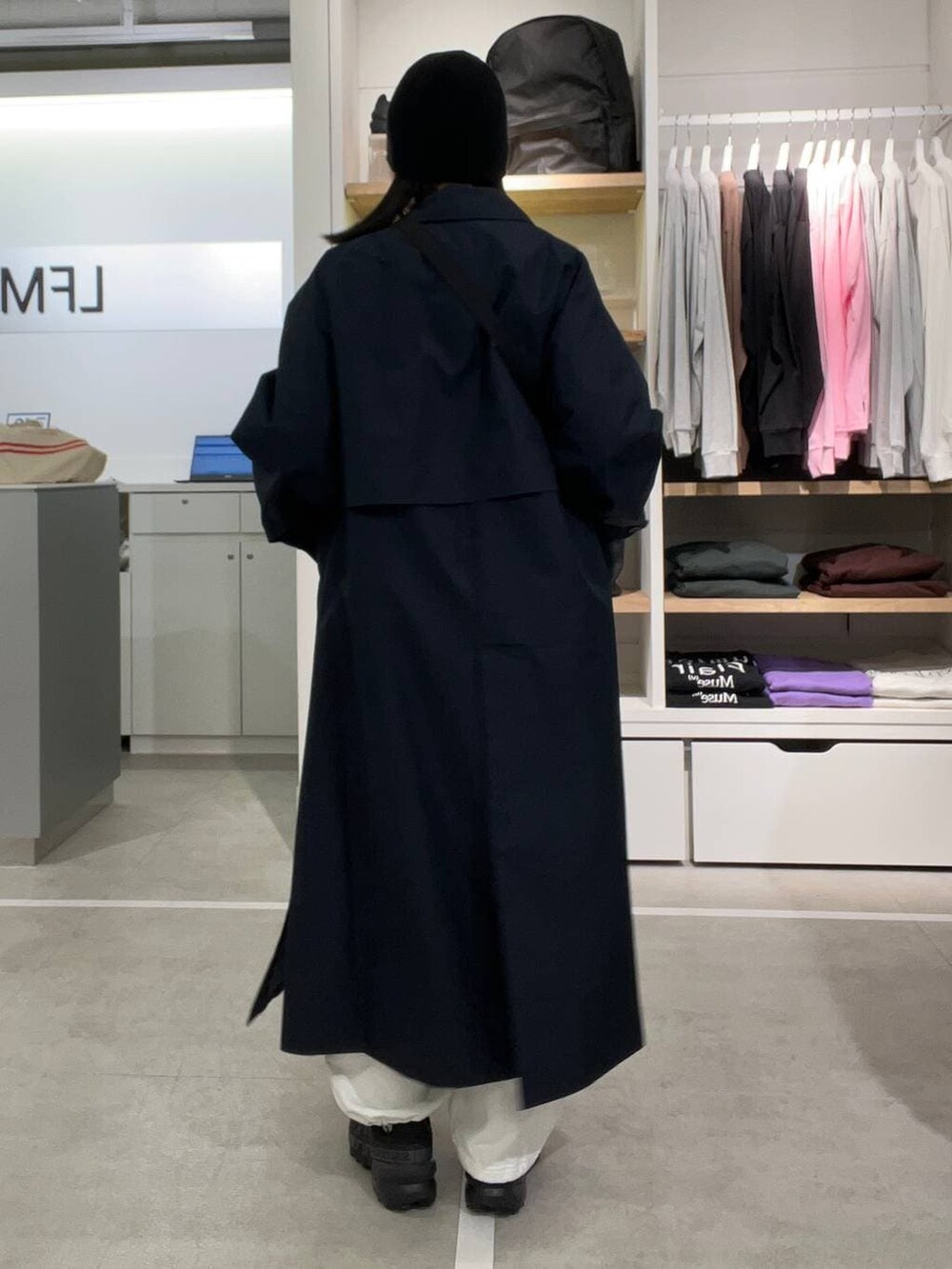 ホワイト系のスウェットパンツ、レッド系のニット/セーター、ブルー系のステンカラーコートを着用したレディースの冬コーディネートの2枚目の写真