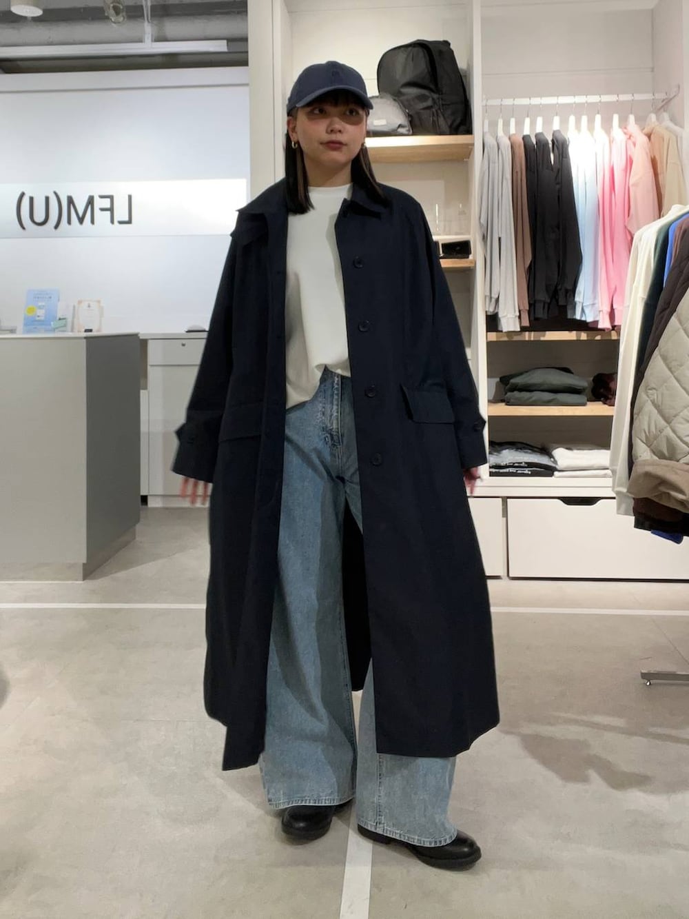 ブラック系のドレスシューズ、ブルー系のデニムパンツ、ブルー系のステンカラーコートを着用したレディースの春コーディネートの3枚目の写真