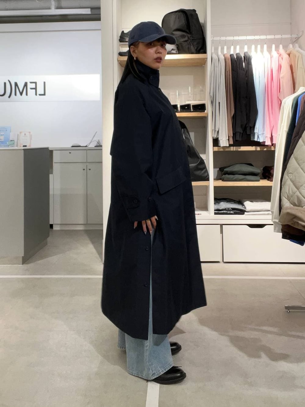 ブラック系のドレスシューズ、ブルー系のデニムパンツ、ブルー系のステンカラーコートを着用したレディースの春コーディネートの4枚目の写真