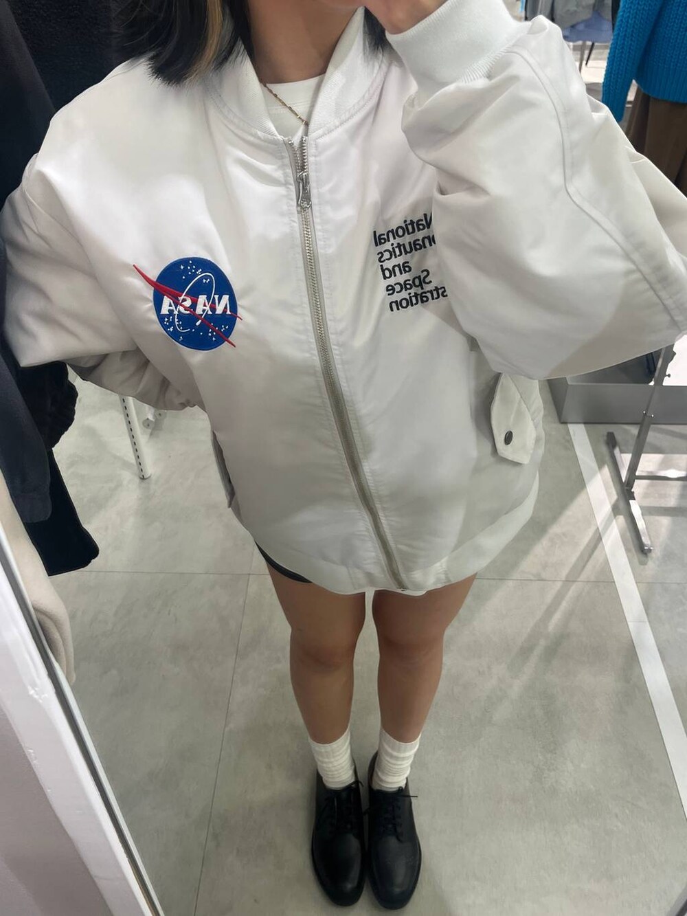 ブラック系のドレスシューズ、ホワイト系のTシャツ/カットソー、グレー系のブルゾンを着用したレディースの秋コーディネートの2枚目の写真