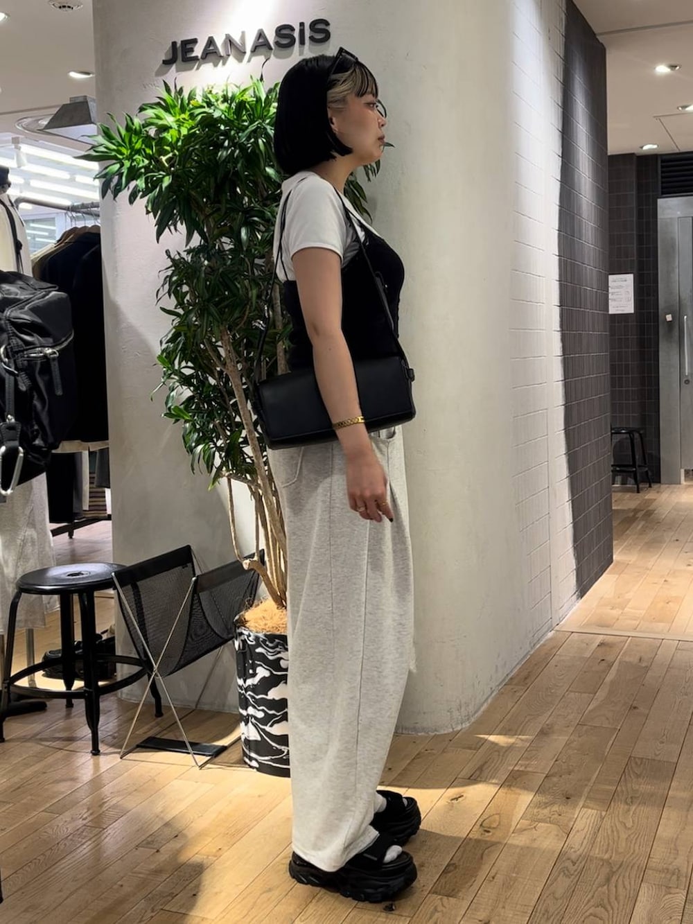 ブラック系のサンダル、ホワイト系のTシャツ/カットソー、ブラック系のショルダーバッグを着用したレディースの夏コーディネートの4枚目の写真