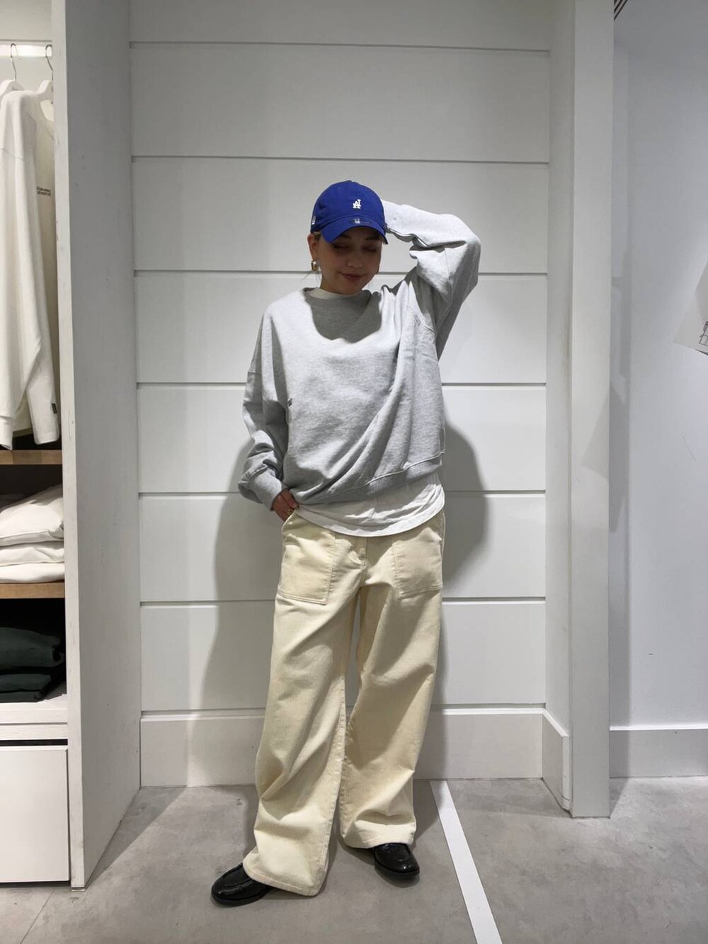 グレー系のスウェット、ホワイト系のその他パンツ、ブルー系のキャップを着用したレディースの秋コーディネートの2枚目の写真
