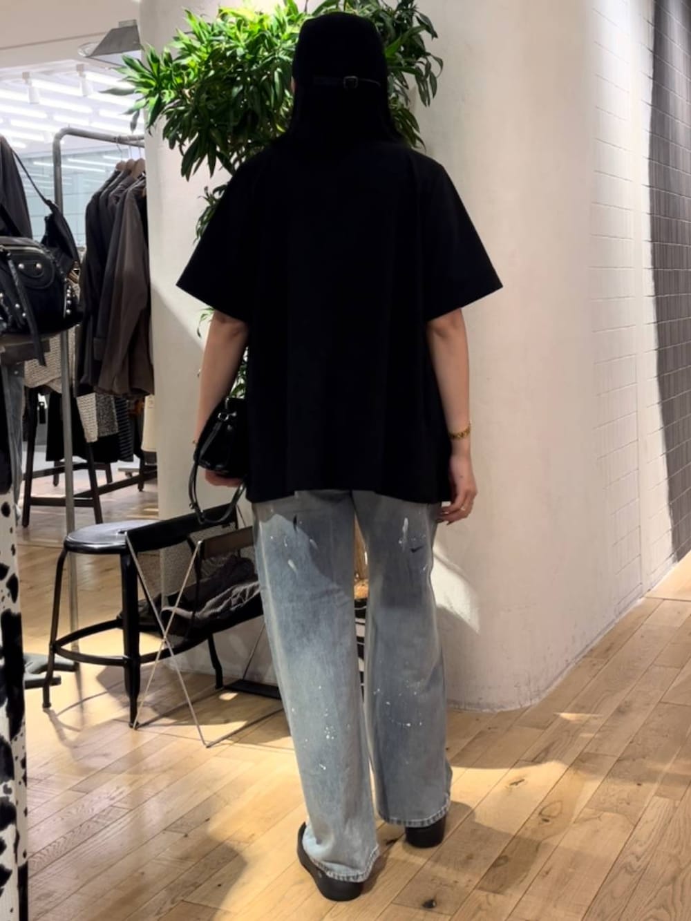 ブルー系のデニムパンツ、ホワイト系のタンクトップ、ブラック系のショルダーバッグを着用したレディースの夏コーディネートの3枚目の写真