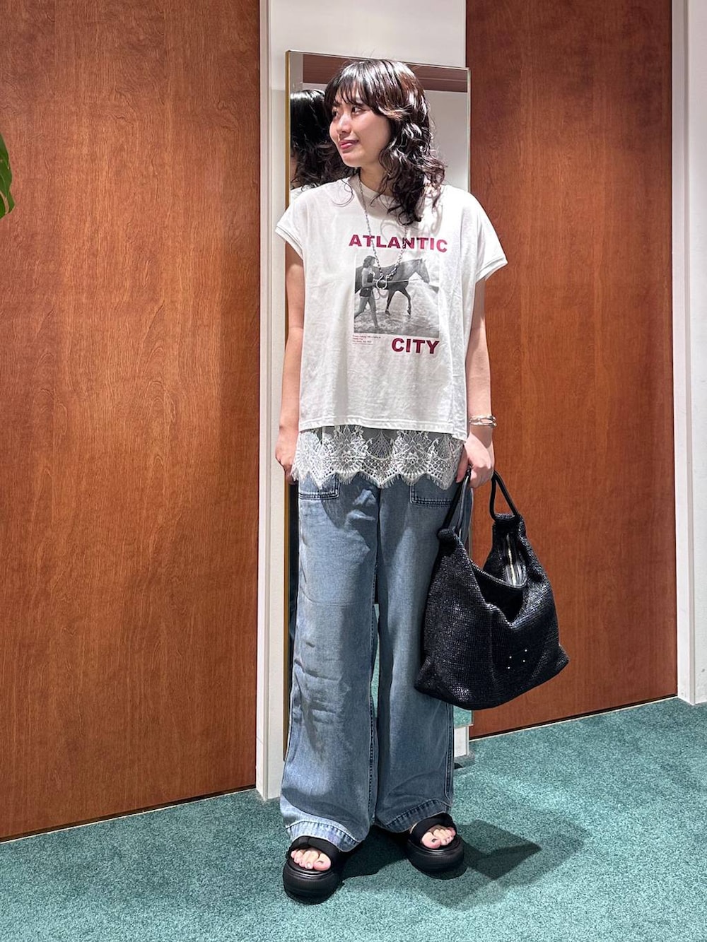 ホワイト系のTシャツ/カットソー、ブルー系のデニムパンツ、ホワイト系のキャミソールを着用したレディースの夏コーディネートの2枚目の写真