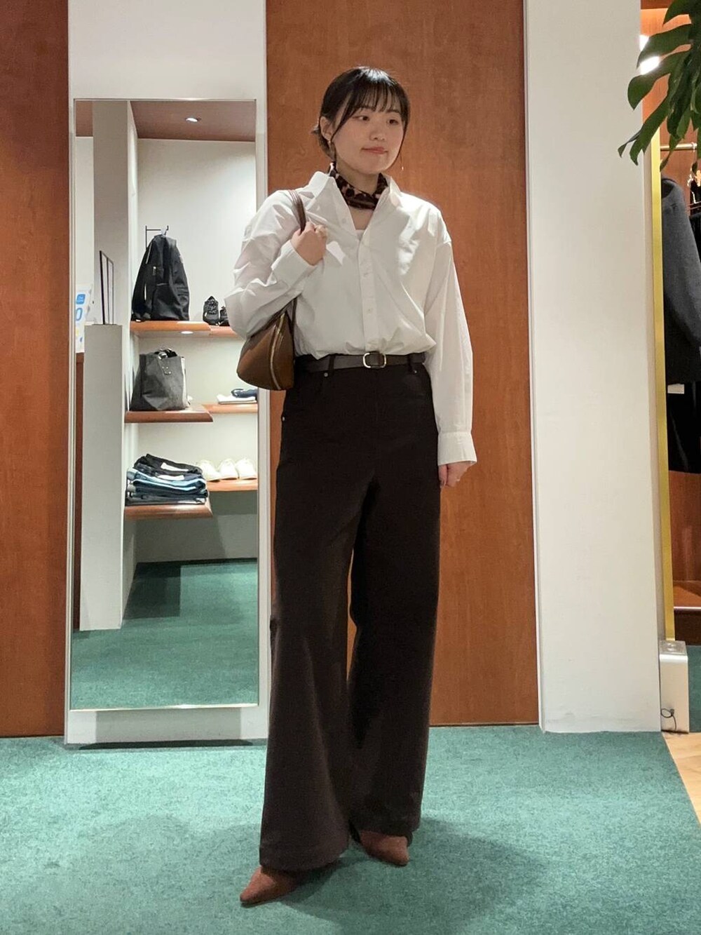 ブラウン系のトートバッグ、ブラウン系のパンプス、ホワイト系のシャツ/ブラウスを着用したレディースの秋コーディネートの2枚目の写真