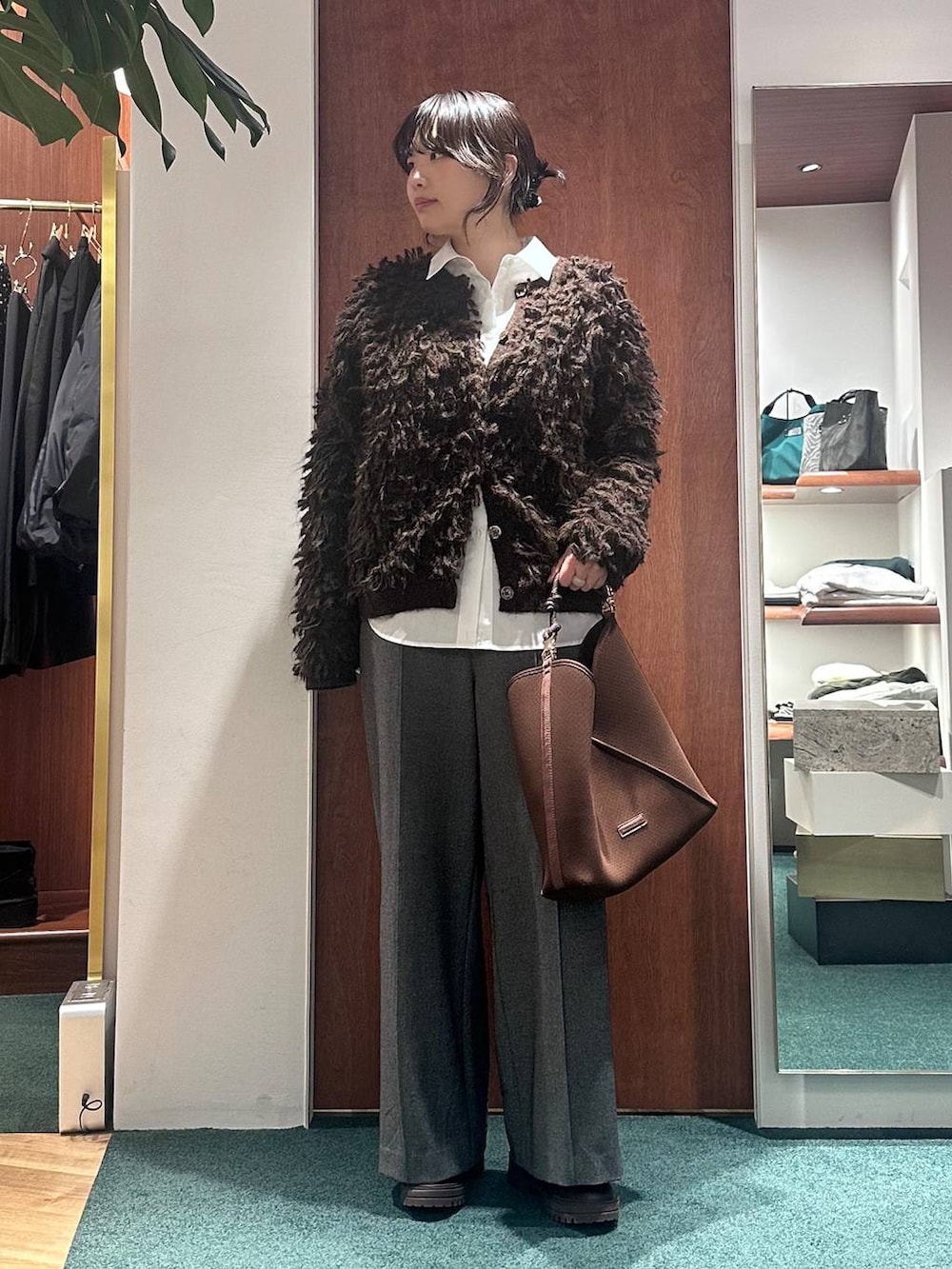 ブラウン系のブーツ、ブラウン系のカーディガン/ボレロ、グレー系のその他パンツを着用したレディースの冬コーディネートの2枚目の写真