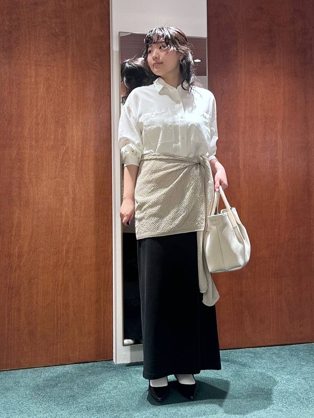 ホワイト系のシャツ/ブラウス、ブラック系のスカート、ブラック系のパンプスを着用したレディースの春コーディネートの2枚目の写真