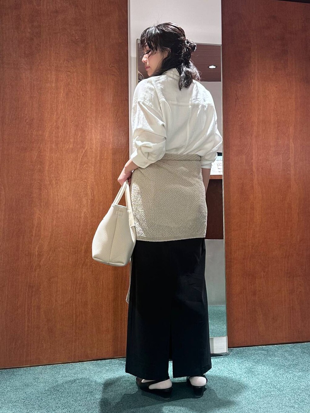 ホワイト系のシャツ/ブラウス、ブラック系のスカート、ブラック系のパンプスを着用したレディースの春コーディネートの4枚目の写真