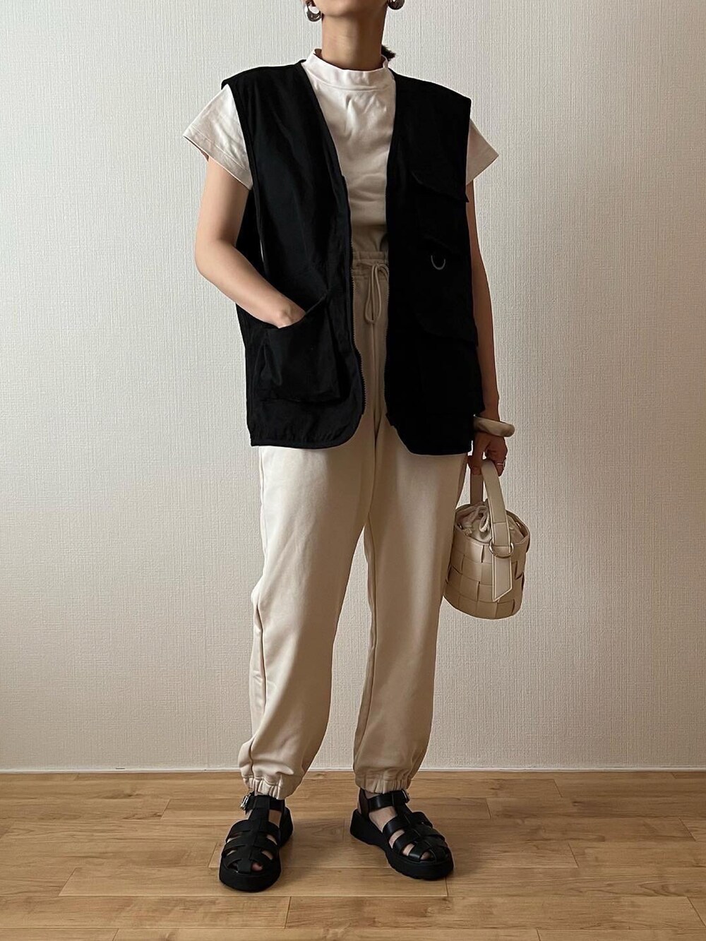 ホワイト系のスウェットパンツ、ホワイト系のTシャツ/カットソー、ブラック系のベストを着用したレディースの夏コーディネートの3枚目の写真