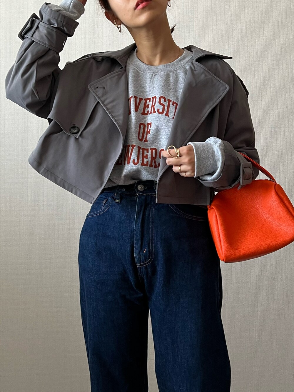 グレー系のスウェット、ブルー系のデニムパンツ、グレー系のスニーカーを着用したレディースの秋コーディネートの2枚目の写真