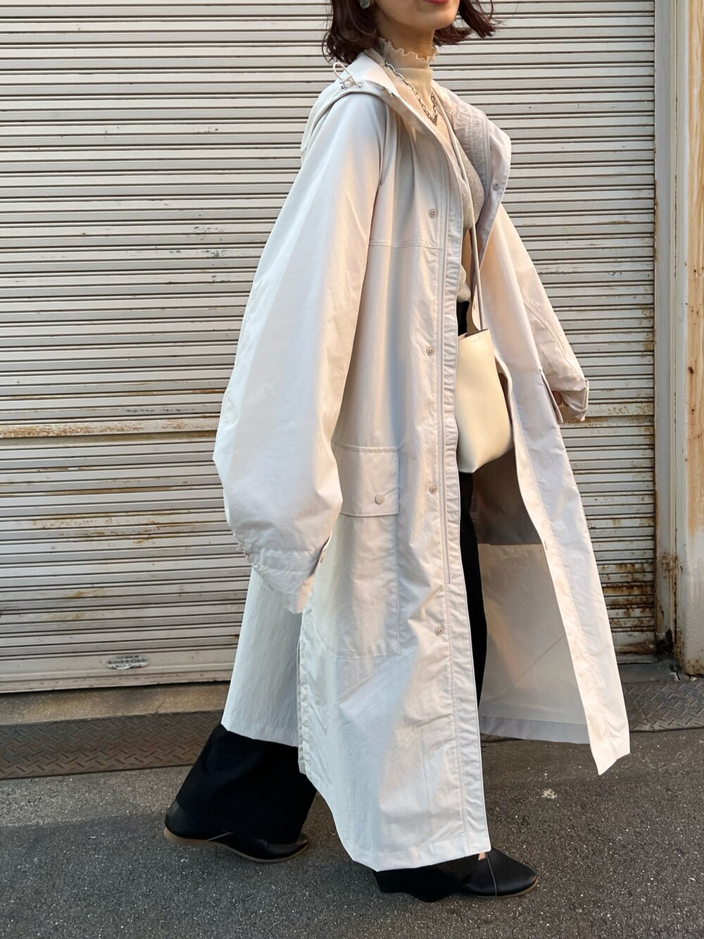 ホワイト系のジャケット/アウター、ブラック系のスラックス、ベージュ系のTシャツ/カットソーを着用したレディースの秋コーディネートの2枚目の写真
